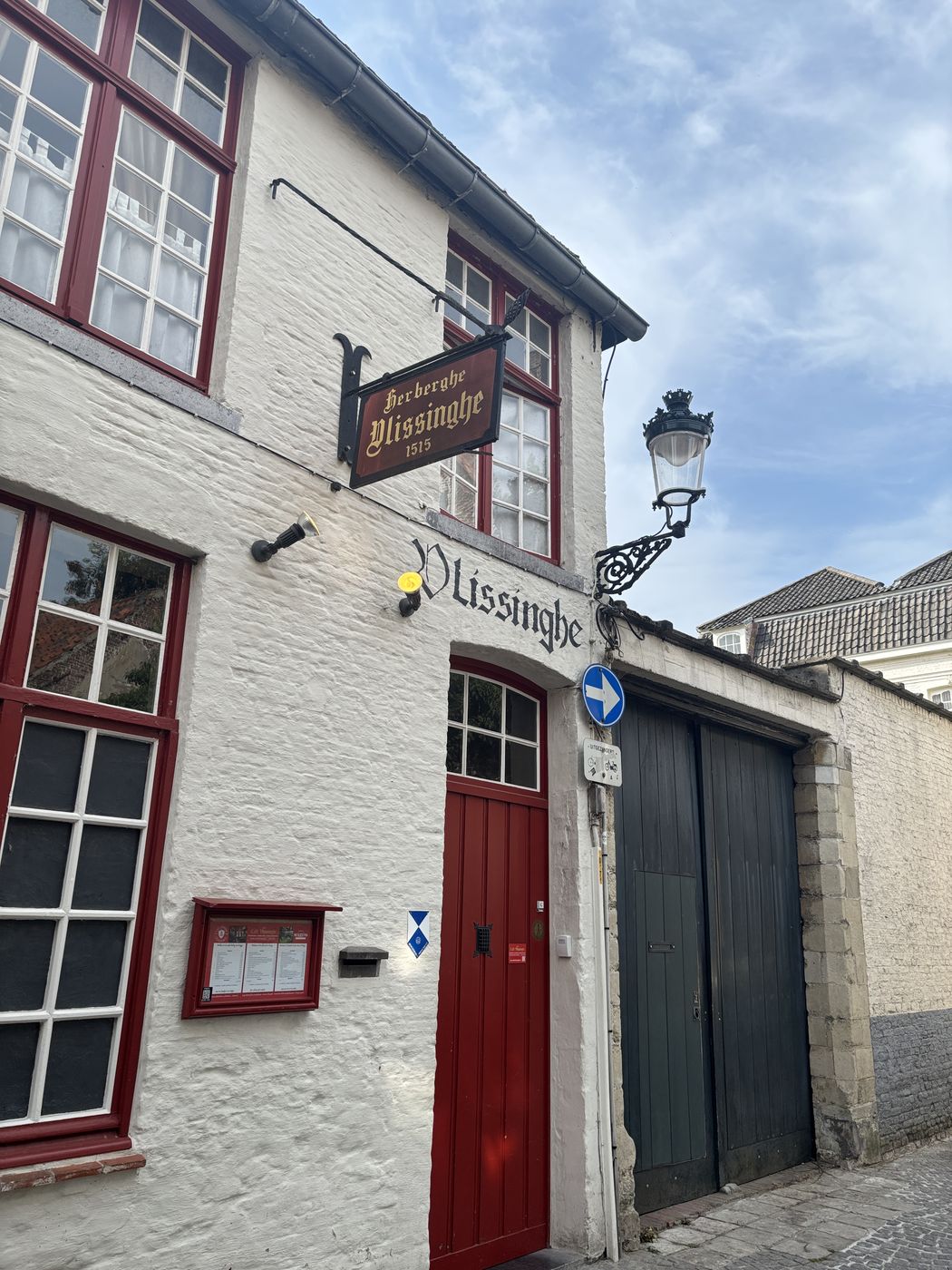 The red door and hanging sign of Café Vlissinghe