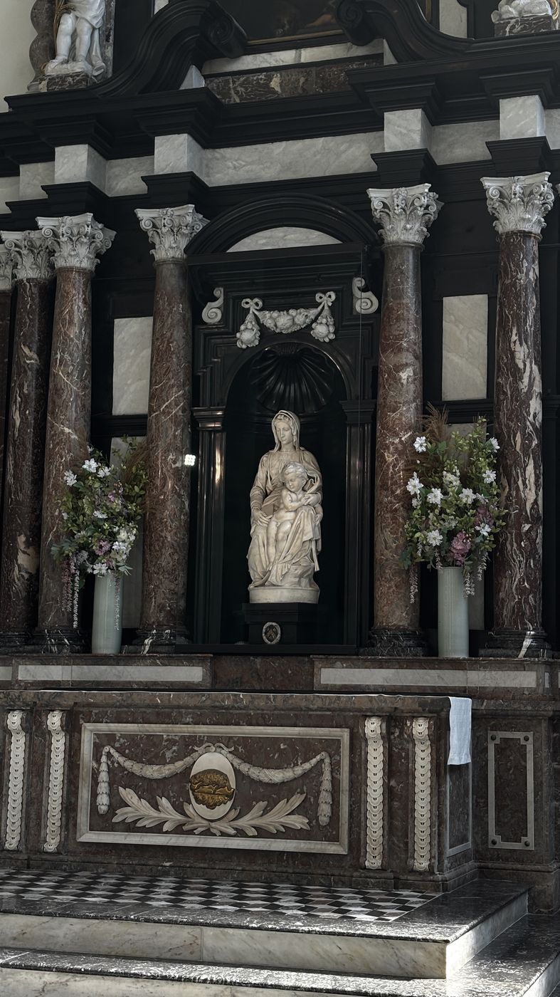 The altar holding Michelangelo’s Madonna and Child, flanked by flowers