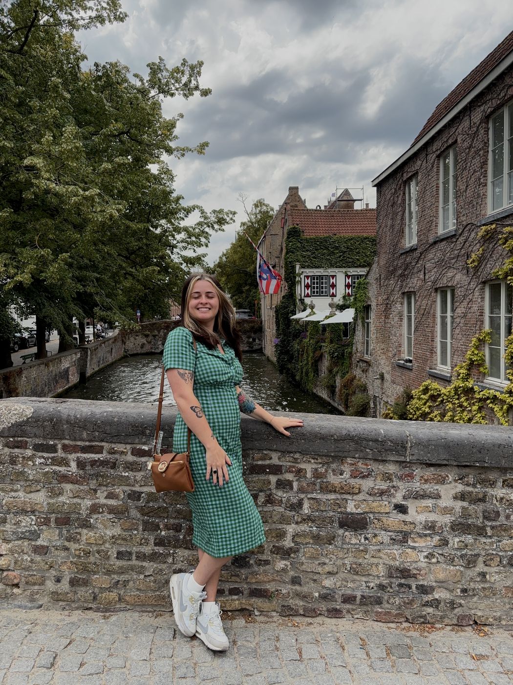 Me in a green dress on a stone bridge over a canal