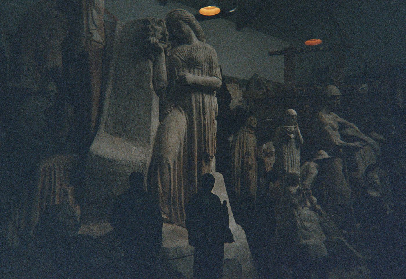 Plaster sculptures under warm lamps inside La Piscine, on film