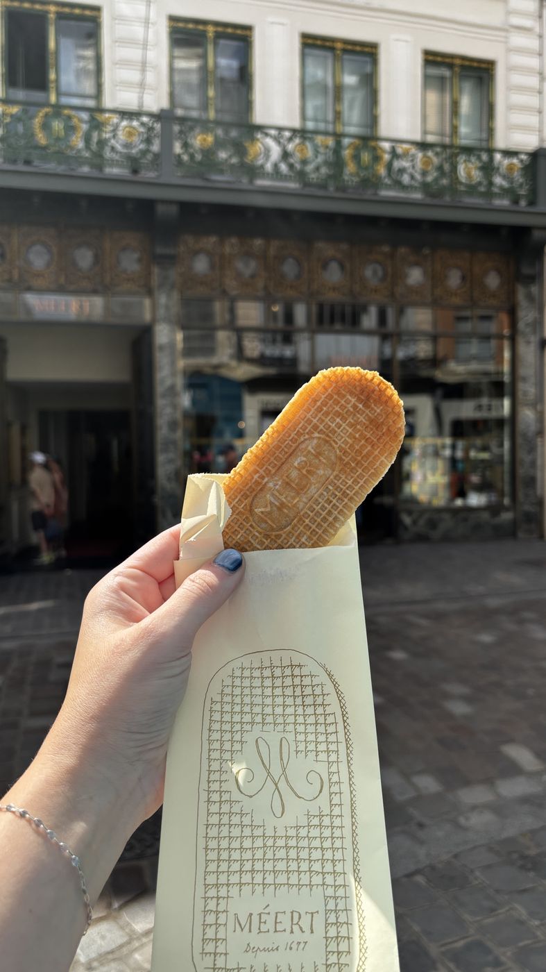 Holding a Méert gaufre outside the shop