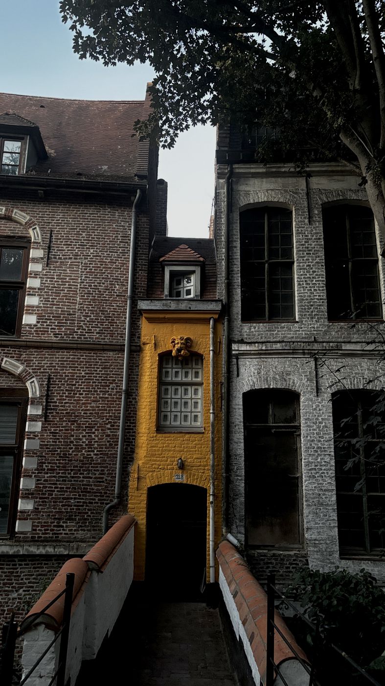 A narrow yellow facade between two buildings