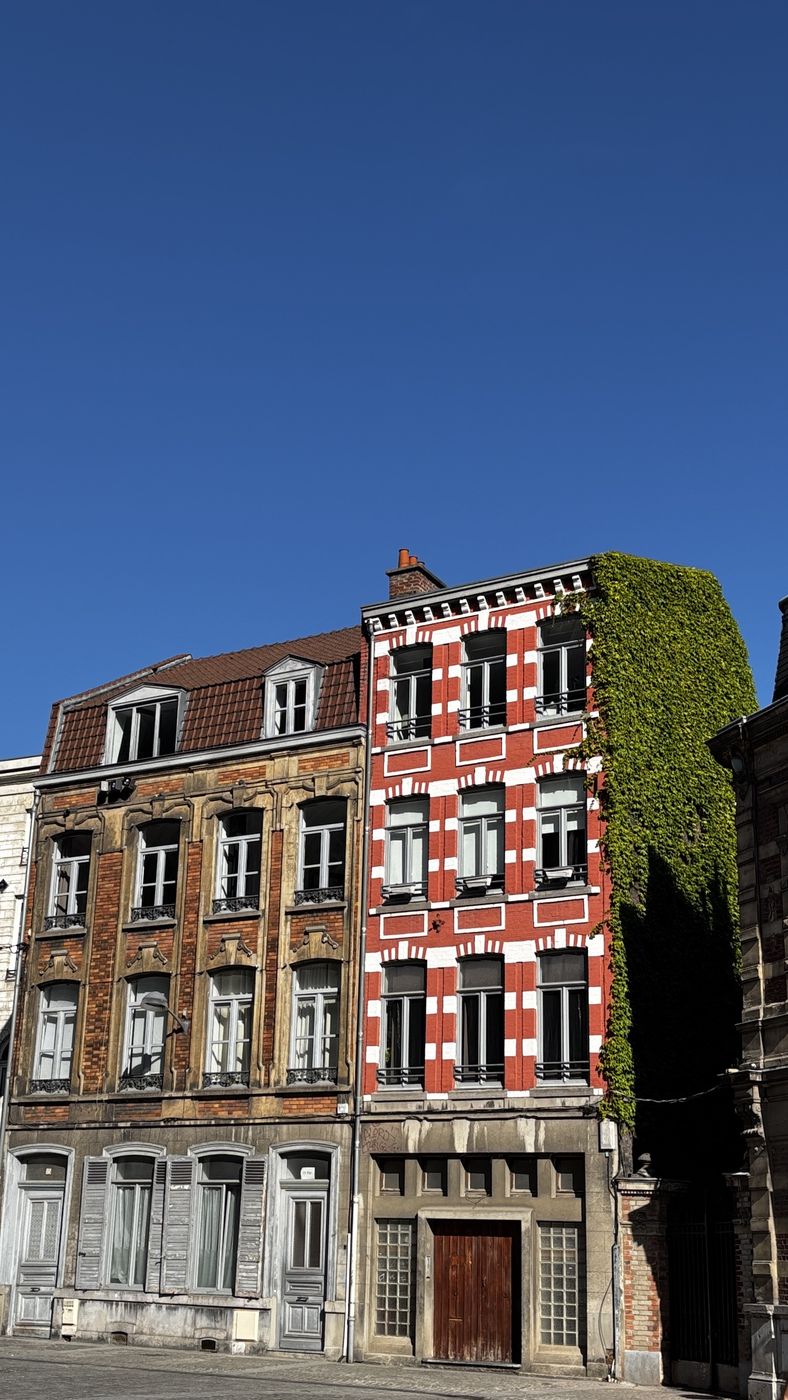 Red and white striped brick house with ivy