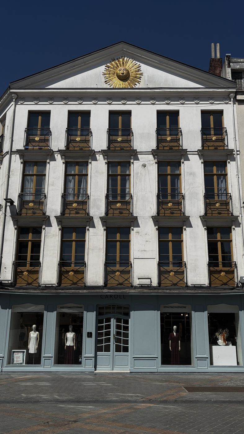 White townhouse with a gold sun above the door
